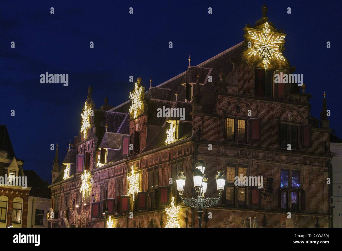 Historisches, dunkel beleuchtetes Gebäude mit Weihnachtsstreifenbeleuchtung, nijmegen, niederlande Stockfoto