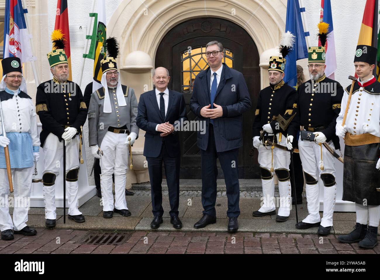 Freiberg, Deutschland. Dezember 2024. Bundeskanzler Olaf Scholz (SPD, l) und der serbische Präsident Aleksandar Vucic stehen vor dem sächsischen Oberbergamt. Thema des Treffens im Erzgebirge ist die nachhaltige Lithiumgewinnung für Batterien für Elektroautos. Quelle: Sebastian Kahnert/dpa/Alamy Live News Stockfoto