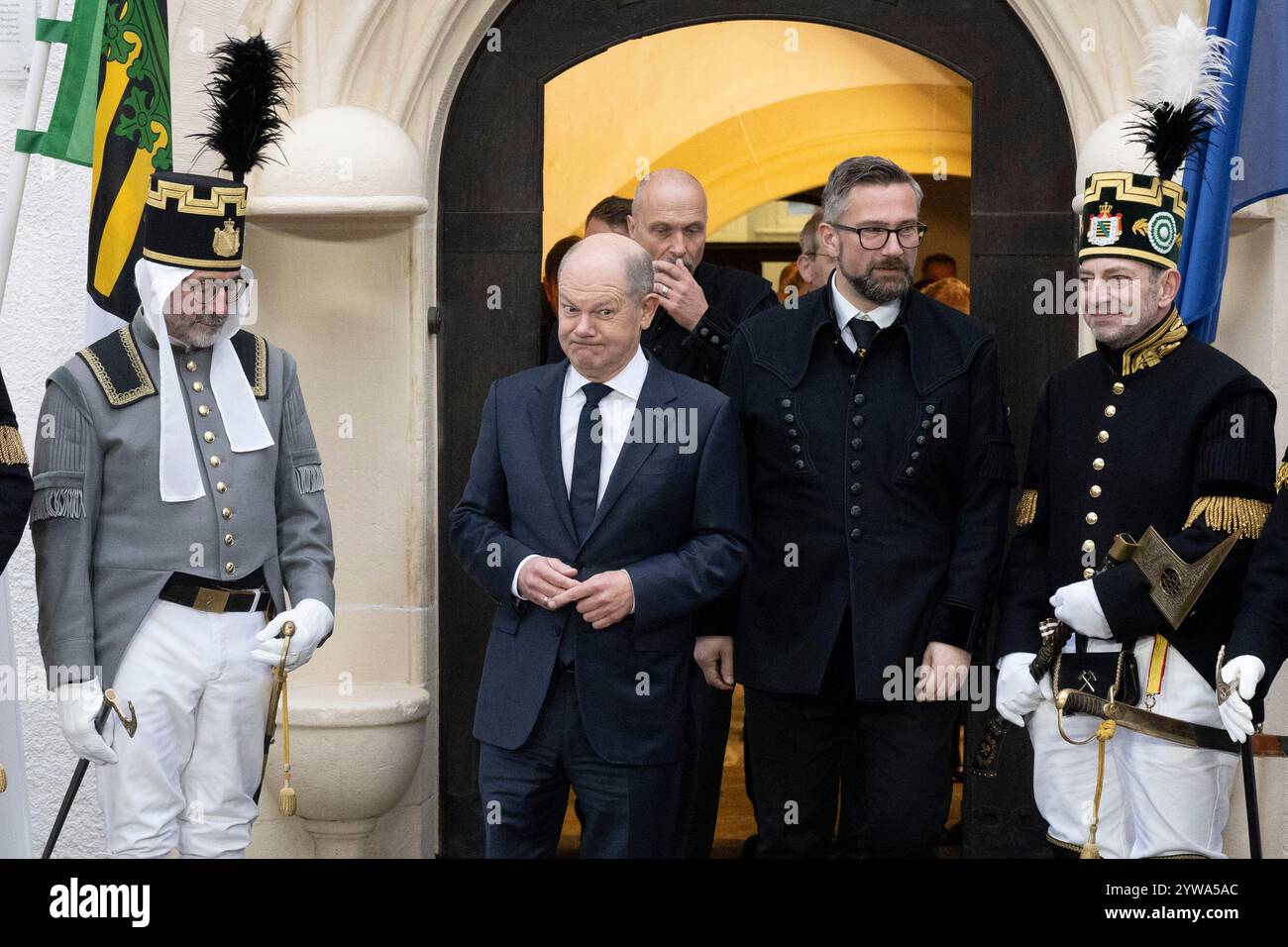 Freiberg, Deutschland. Dezember 2024. Bundeskanzler Olaf Scholz (SPD, l) wartet auf die Ankunft des serbischen Präsidenten vor dem sächsischen Oberbergamt neben dem sächsischen Wirtschaftsminister Martin Dulig (SPD). Thema des Treffens im Erzgebirge ist die nachhaltige Lithiumgewinnung für Batterien für Elektroautos. Quelle: Sebastian Kahnert/dpa/Alamy Live News Stockfoto