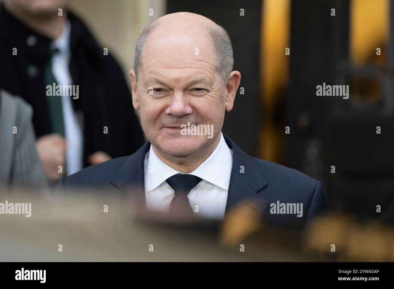 Freiberg, Deutschland. Dezember 2024. Bundeskanzler Olaf Scholz (SPD) wartet auf die Ankunft des serbischen Präsidenten vor dem sächsischen Bergbauamt. Thema des Treffens im Erzgebirge ist die nachhaltige Gewinnung von Lithium für Batterien für Elektroautos. Quelle: Sebastian Kahnert/dpa/Alamy Live News Stockfoto