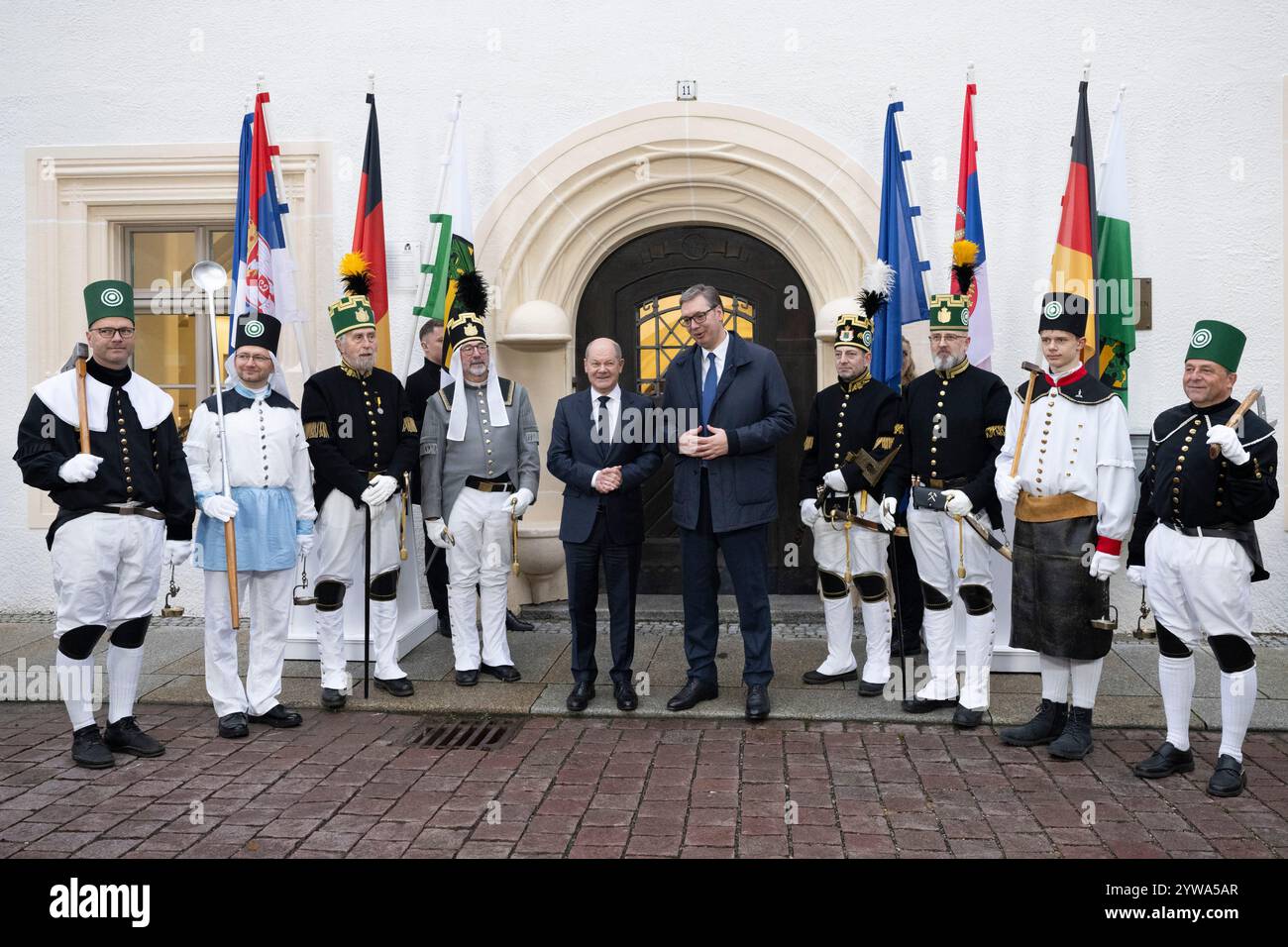 Freiberg, Deutschland. Dezember 2024. Bundeskanzler Olaf Scholz (SPD, l) und der serbische Präsident Aleksandar Vucic stehen vor dem sächsischen Oberbergamt. Thema des Treffens im Erzgebirge ist die nachhaltige Lithiumgewinnung für Batterien für Elektroautos. Quelle: Sebastian Kahnert/dpa/Alamy Live News Stockfoto
