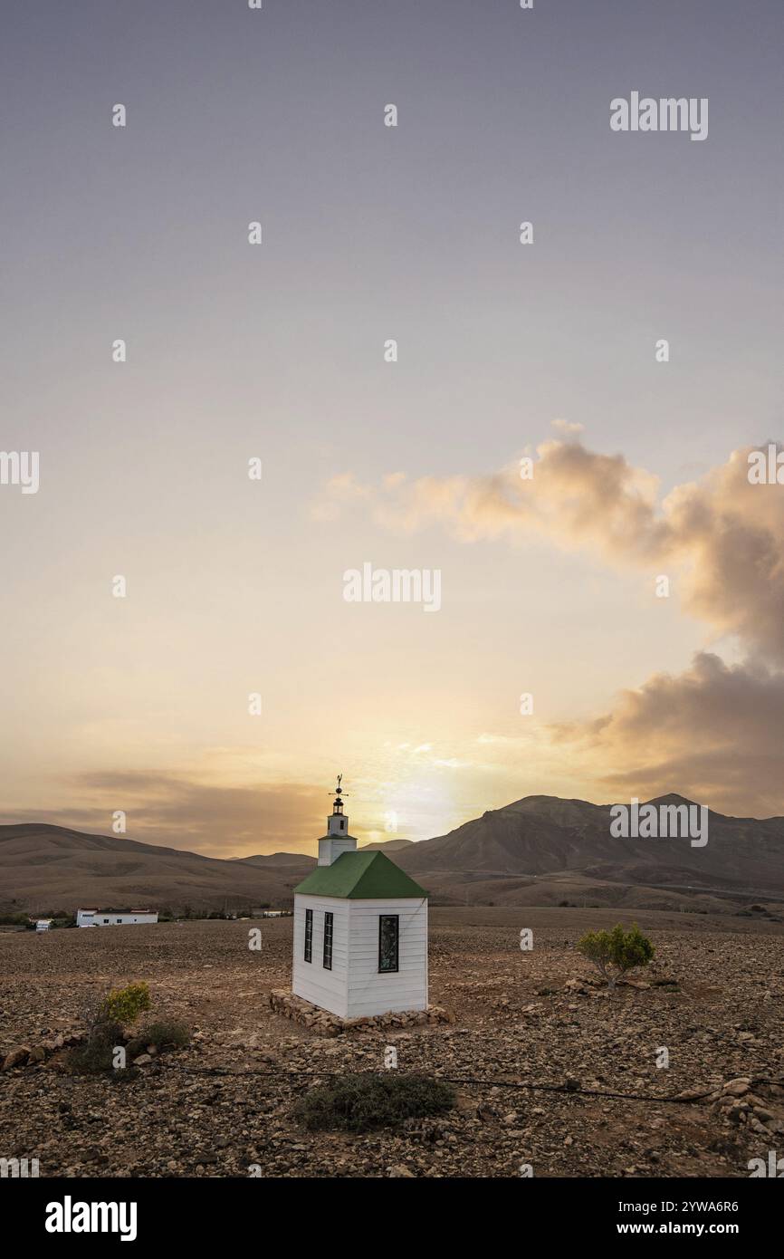 Kleine süße weiße Holzkapelle in einer kargen vulkanischen Landschaft. Sonnenaufgang, Landschaftsaufnahme der Kirche Ermita Protestante de Violante auf der Insel Stockfoto