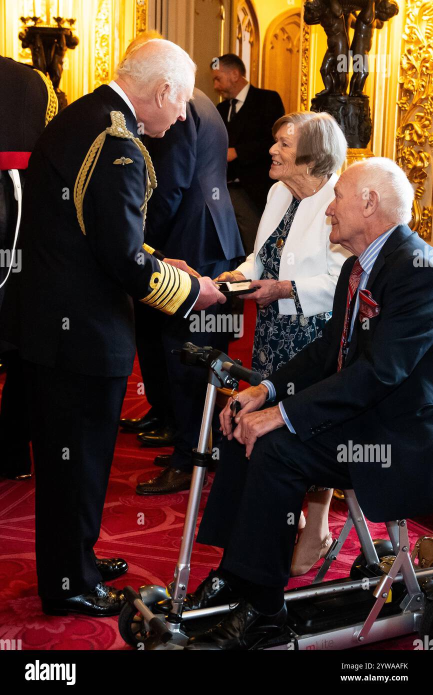 König Karl III. Überreicht Mrs. Carole Henbury ein Elisabeth-Emblem für den leitenden Feuerwehrmann Leslie Marsh, West Midlands Fire Service während der Eröffnungszeremonie in Windsor Castle, Berkshire. Der König überreicht das erste Elisabeth-Emblem den nächsten Angehörigen ehemaliger Feuerwehrleute, Polizisten und anderer Beamter, die im Dienst starben. Bilddatum: Dienstag, 10. Dezember 2024. Stockfoto