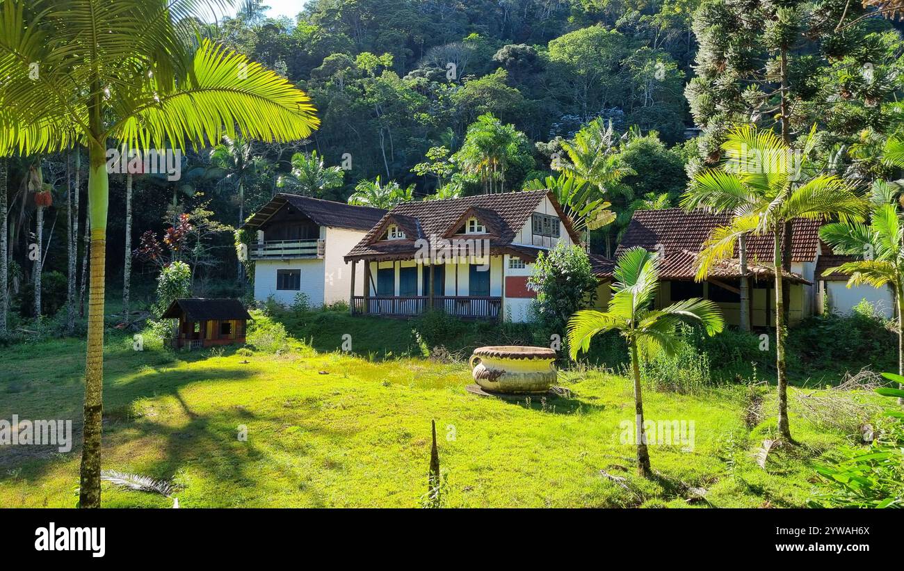 Inmitten des üppigen tropischen Grüns steht das Haus in ruhiger Ruhe – seine verwitterten Dachziegel und der rustikale Charme deuten auf unzählige Erinnerungen hin. Stockfoto