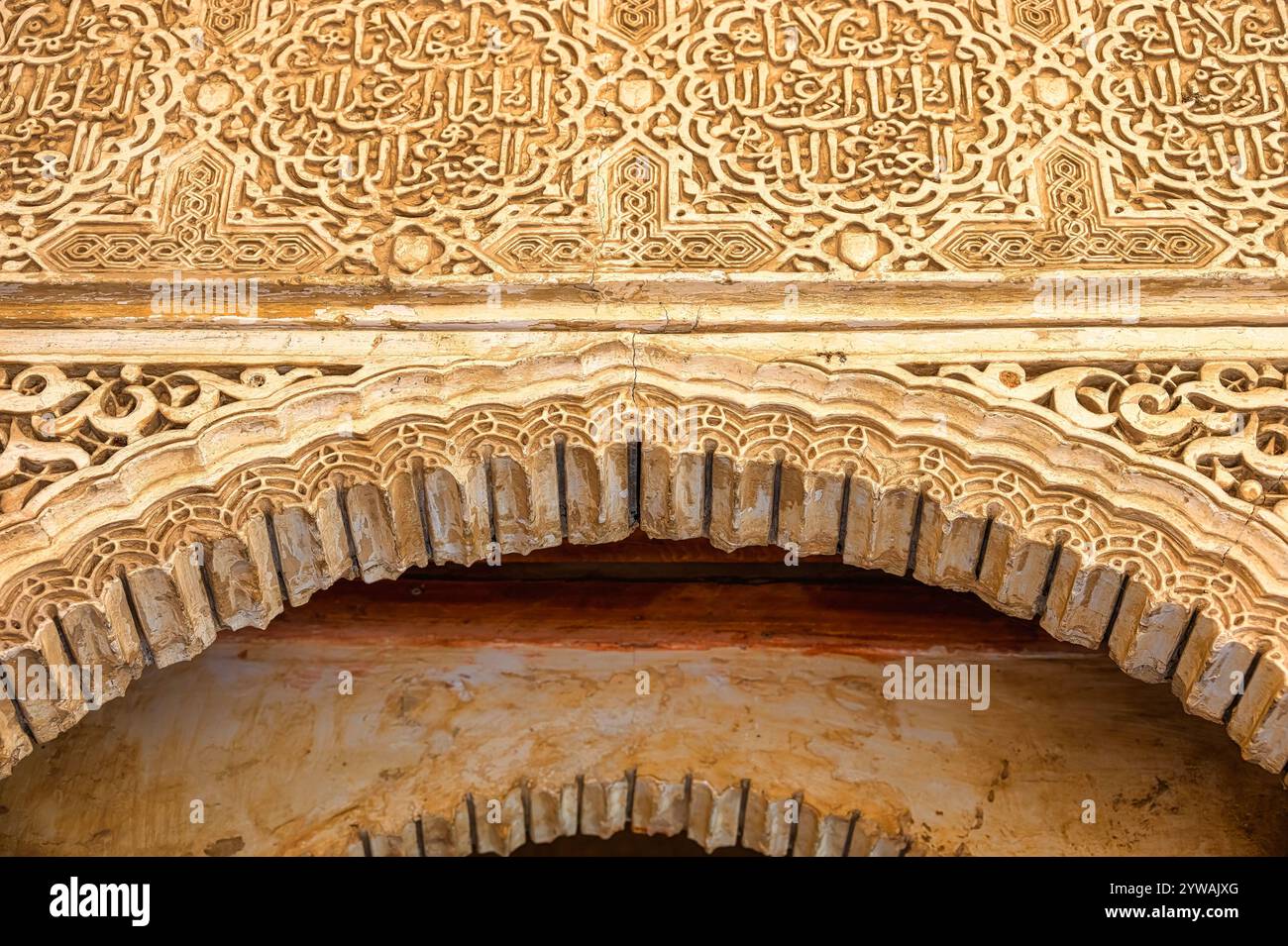 Granada, Spanien - 20. September 2024: Bogen im alten islamischen Stil mit dekorativen Reliefschnitzereien an einer Wand im Alhambra-Palast. Stockfoto