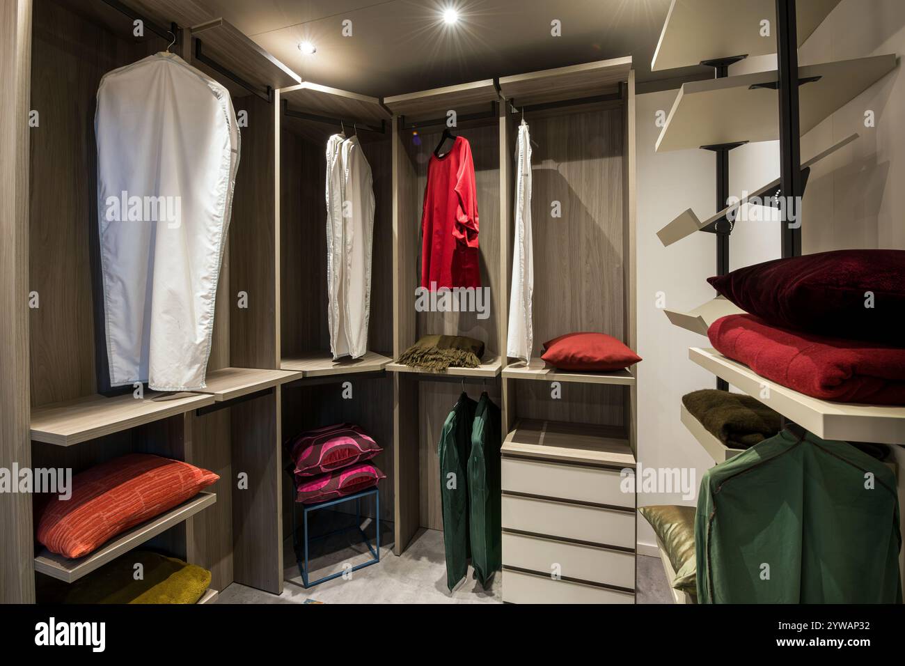 Moderner begehbarer Kleiderschrank mit organisierter Kleidung, farbenfrohen Kissen und effizienten Aufbewahrungslösungen Stockfoto