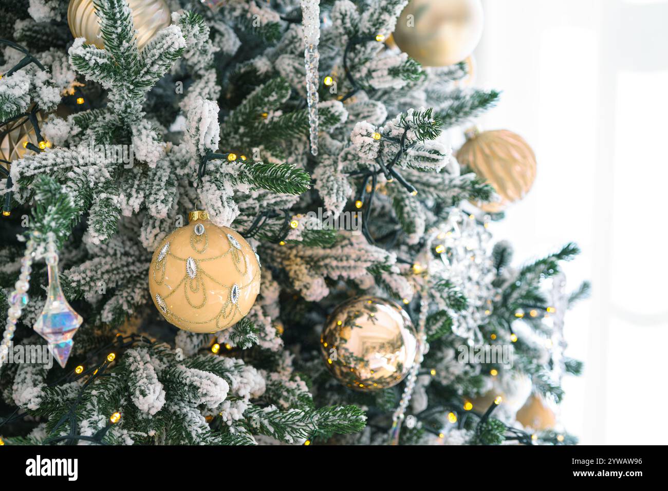 Geschmückter Weihnachtsbaum mit mattierten Zweigen, glitzernden Ornamenten und leuchtenden Lichtern isoliert auf weißem Hintergrund. Festliche Atmosphäre für Urlaub c Stockfoto