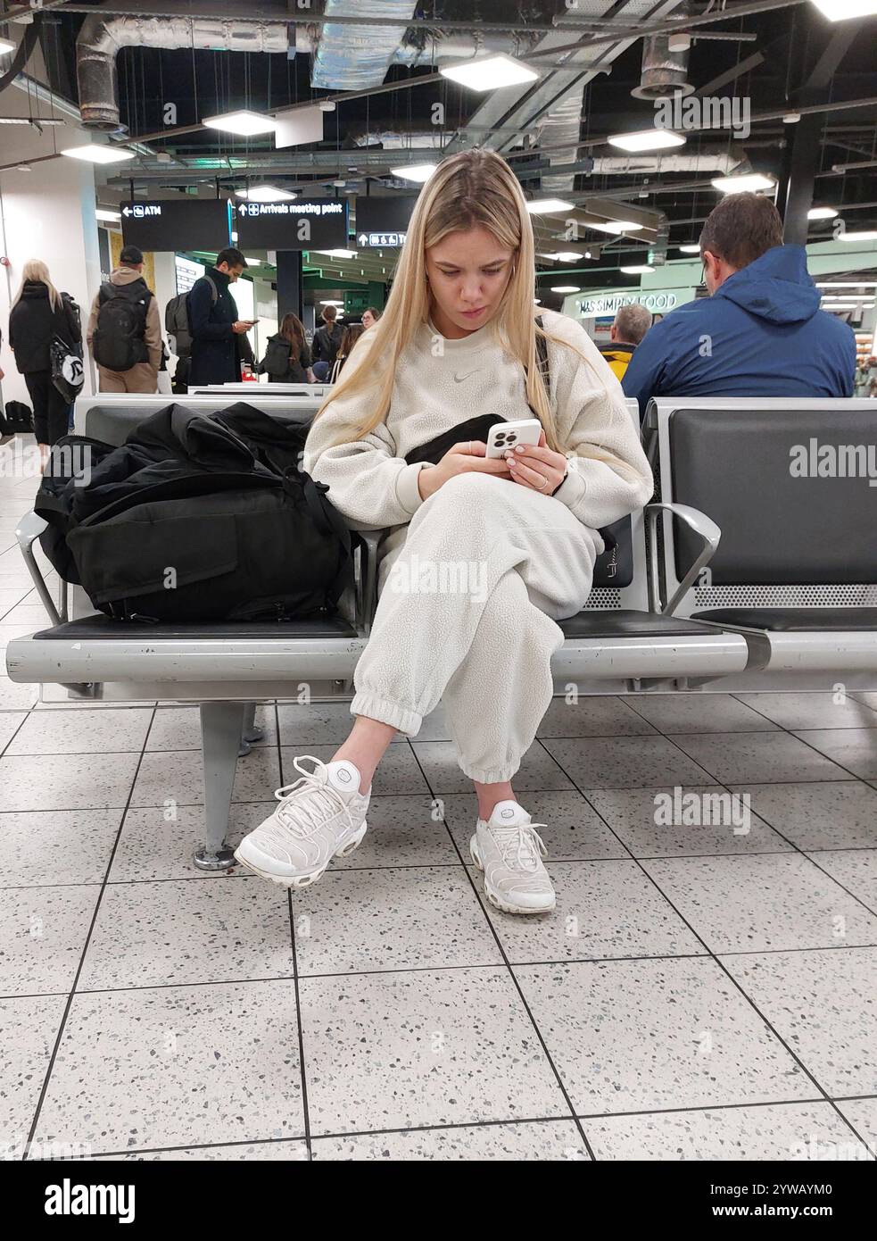 Junge Frau, die auf ihren Flug am Flughafen luton in england uk wartete Stockfoto