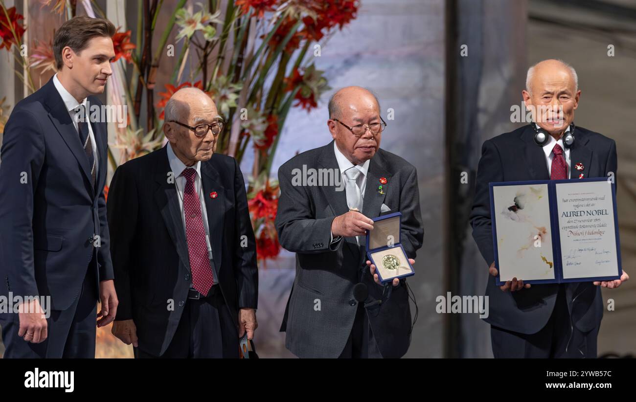 Oslo, Norwegen 10. Dezember 2024 Terumi Tanaka, Generalsekretär von Nihon Hidankyo, einem 92-jährigen Überlebenden des Atombombenanschlags von Nagasaki vor 68 Jahren, und Toshiyuki Mimati und Shigemitsu Tanaka, wird während der Verleihung des Friedensnobelpreises am 10. Dezember 2024 im Rathaus Oslo, Norwegen, von Jorgen Watne Frydnes, Vorsitzender des norwegischen Nobelkomitees, mit dem Friedensnobelpreis 2024 ausgezeichnet. Quelle: Nigel Waldron/Alamy Live News Stockfoto