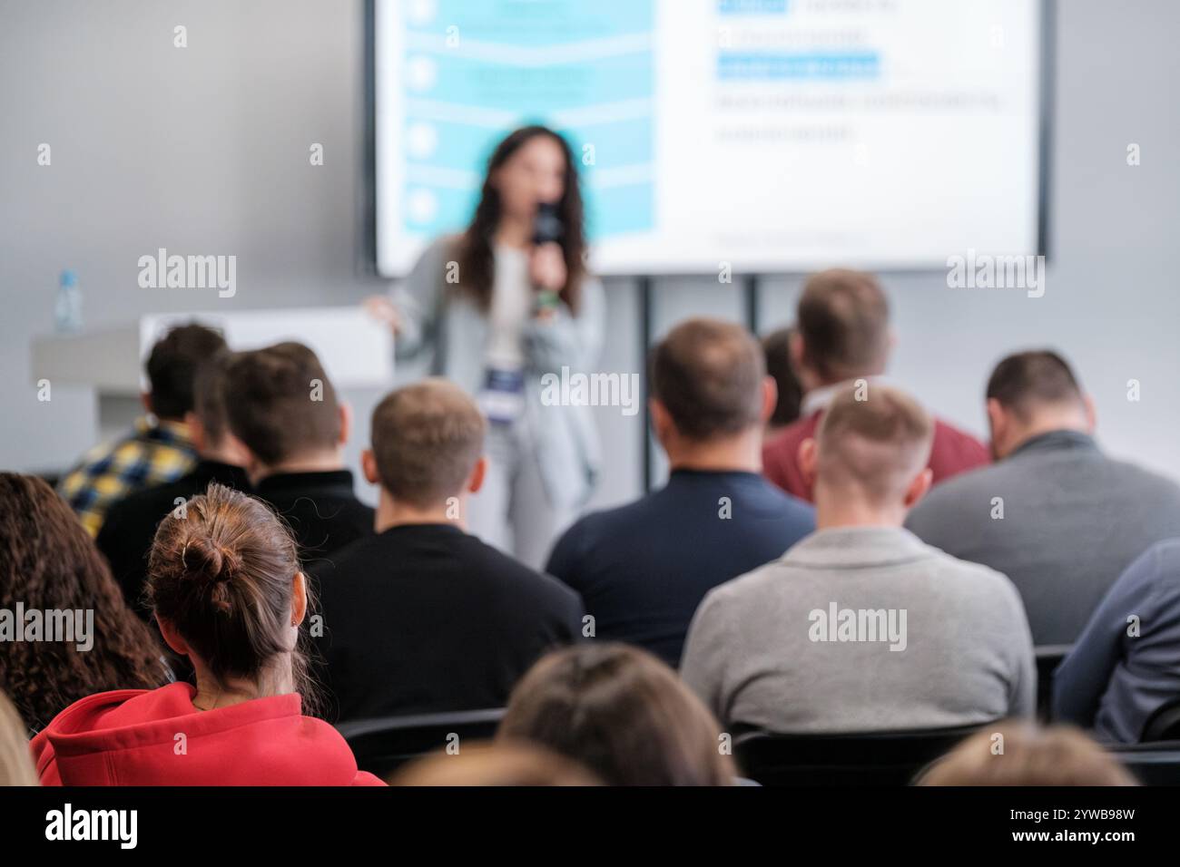 Das Publikum hört aufmerksam zu, wie der Sprecher einen professionellen Konferenzvortrag vorstellt. Konzentrieren Sie sich auf die emotionale Bindung der Teilnehmer. Stockfoto