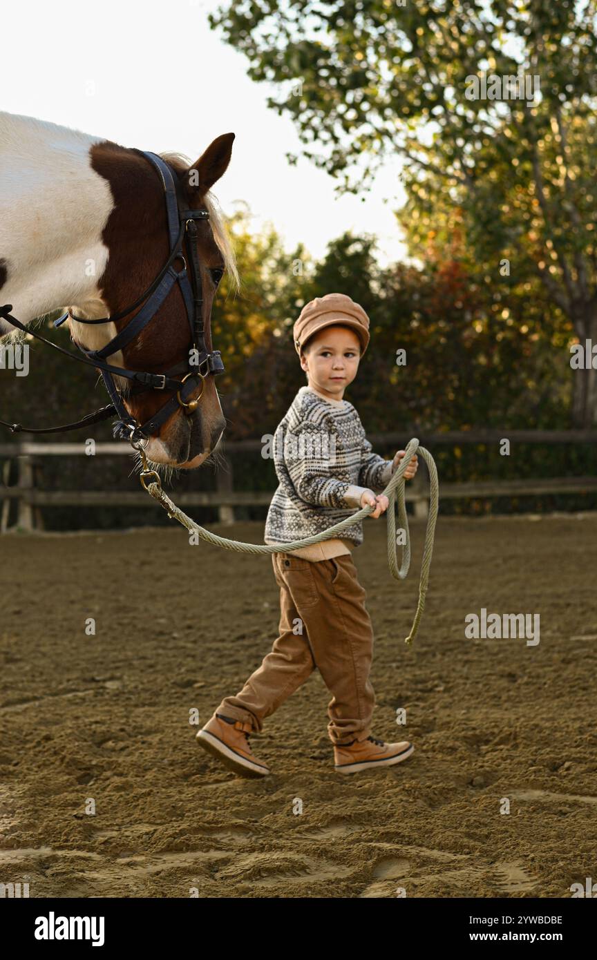 Junge auf dem Land beobachten Feinde und Reiter auf einer Farm Stockfoto