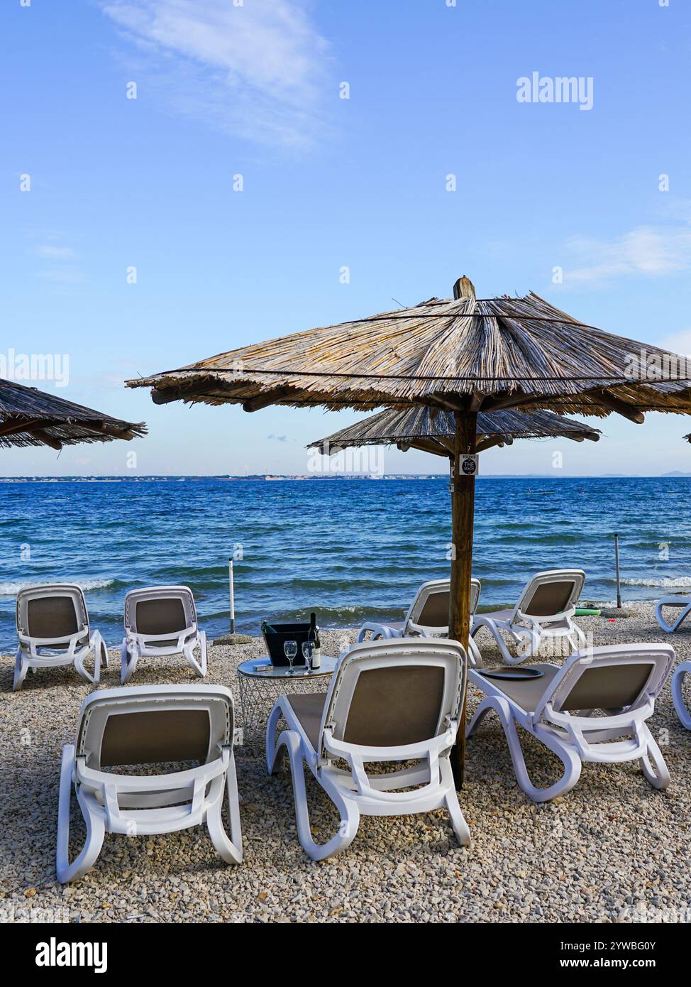 Leeres Strandcafé ohne Besucher nach Ende der Saison, Schilfsonnenschirme, leere Liegen Stockfoto