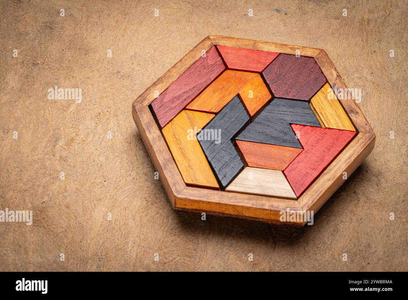 Holzhexagon Tangram Puzzle gegen strukturierte handgemachte Rindenpapier, Gehirn Teaser und lustiges Spiel mit mehreren Möglichkeiten zu lösen Stockfoto
