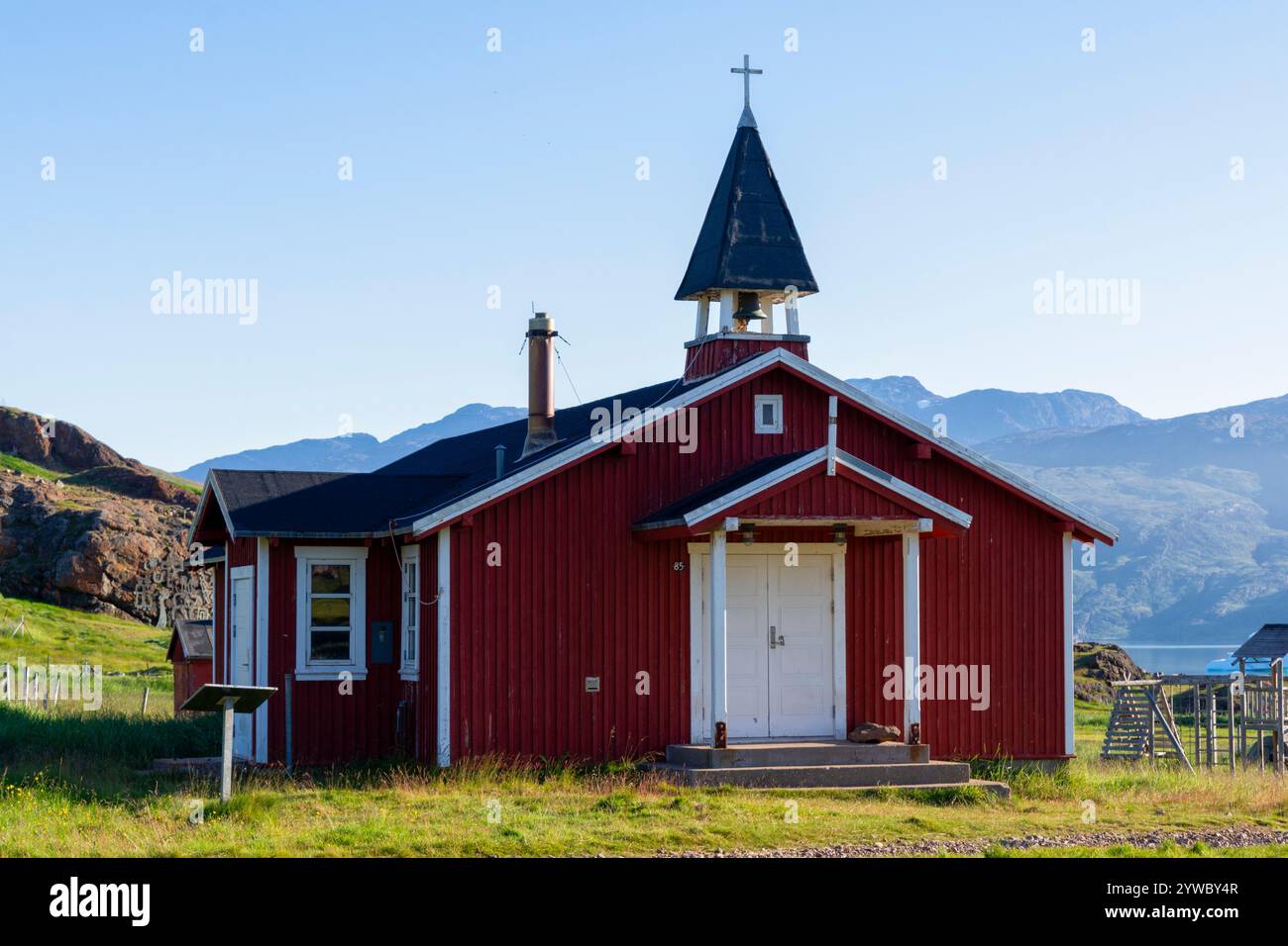 Rote Holzkirche mit Bergen und Tunulliarfik Fjord im Hintergrund. Qassiarsuk, Brattahlíð, Südwestgrönland, Südgrönland, Dänemark Stockfoto