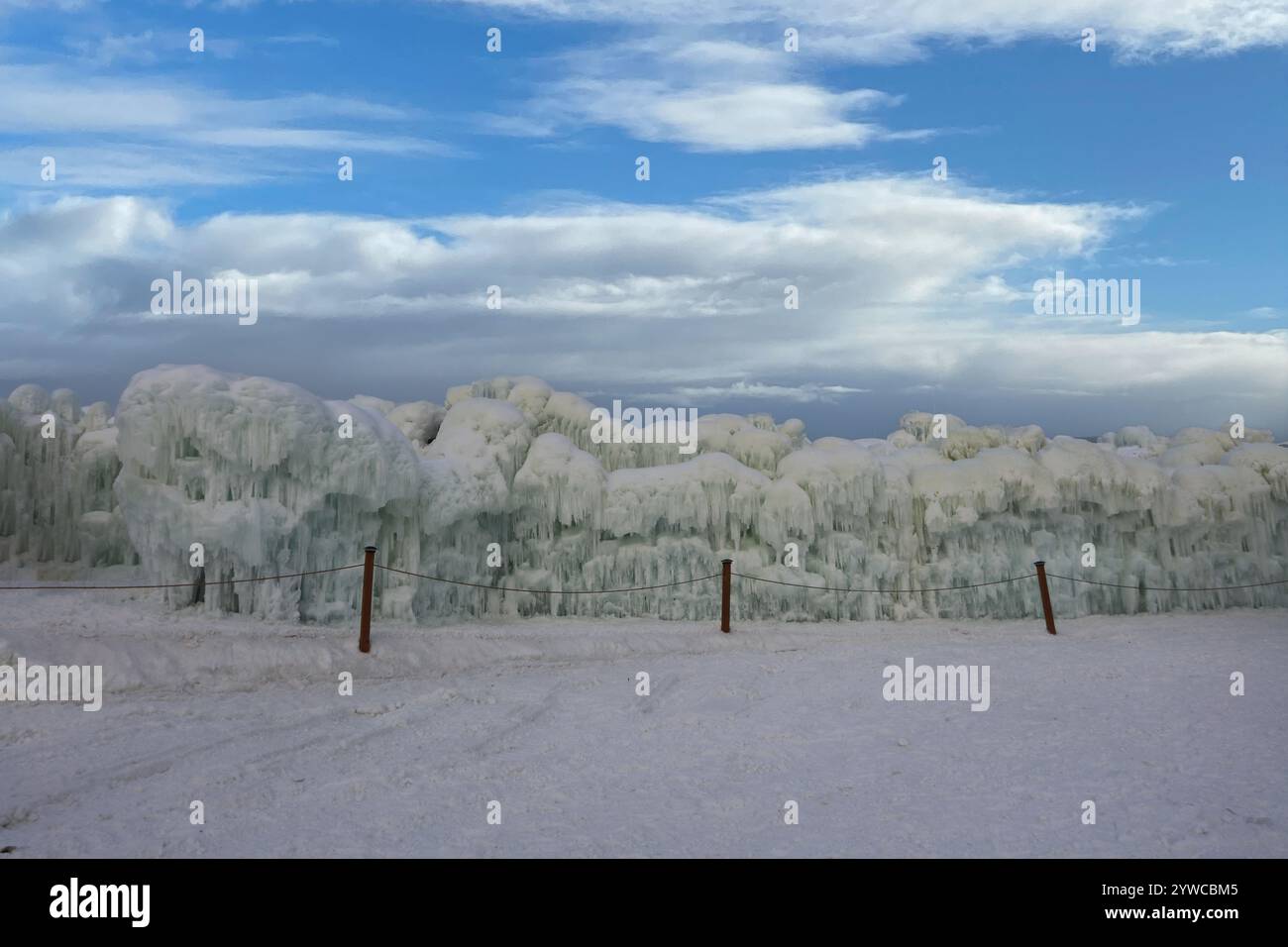 Eine abgesicherte Wand aus gefrorenem Eis und Eiszapfen am Himmel in Ice Castles im Genfer See, Wisconsin, USA Stockfoto