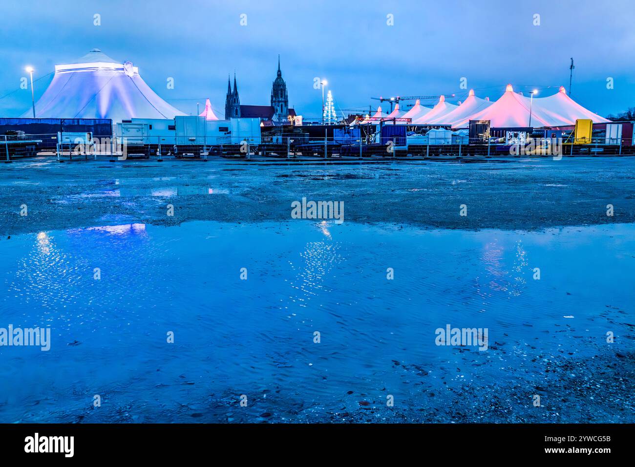 Tollwood Winterfestival auf der Theresienwiese, München, Dezember 2024 Deutschland, München, Dezember 2024, Tollwood Winterfestival, die Theresienwiese mit Zelten und Paulskirche spiegelt sich im Wasser der Pfützen, nach den Regentagen haben sich Wasserpfützen gebildet, Dämmerung, Blaue Stunde, das Winter-Tollwood geht vom 26. November bis 22. November. Dezember 2024, Winter, Kultur, Weihnachtszeit, Veranstaltung, *** Tollwood Winterfestival auf der Theresienwiese, München, Dezember 2024 Deutschland, München, Dezember 2024, Tollwood Winterfestival, die Theresienwiese mit Zelten und der St. Pauls Kirche ist reflektiert Stockfoto