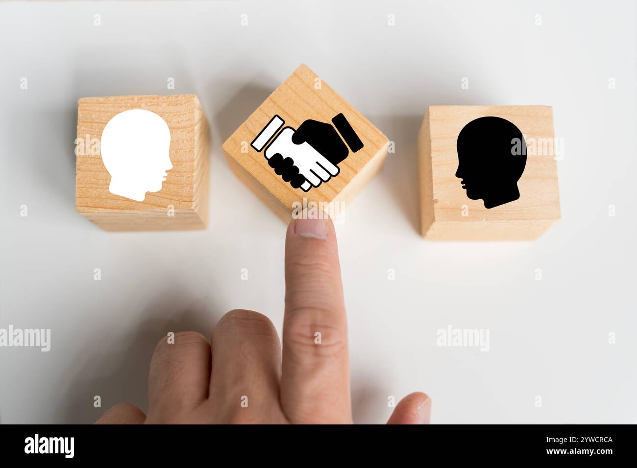 Verhandlungskonzept. Holzblock mit Handshake-Symbol und Geschäftsmann-Symbol für Verhandlung, Vereinbarung, Zusammenarbeit, Geschäftspartnerschaft. Stockfoto