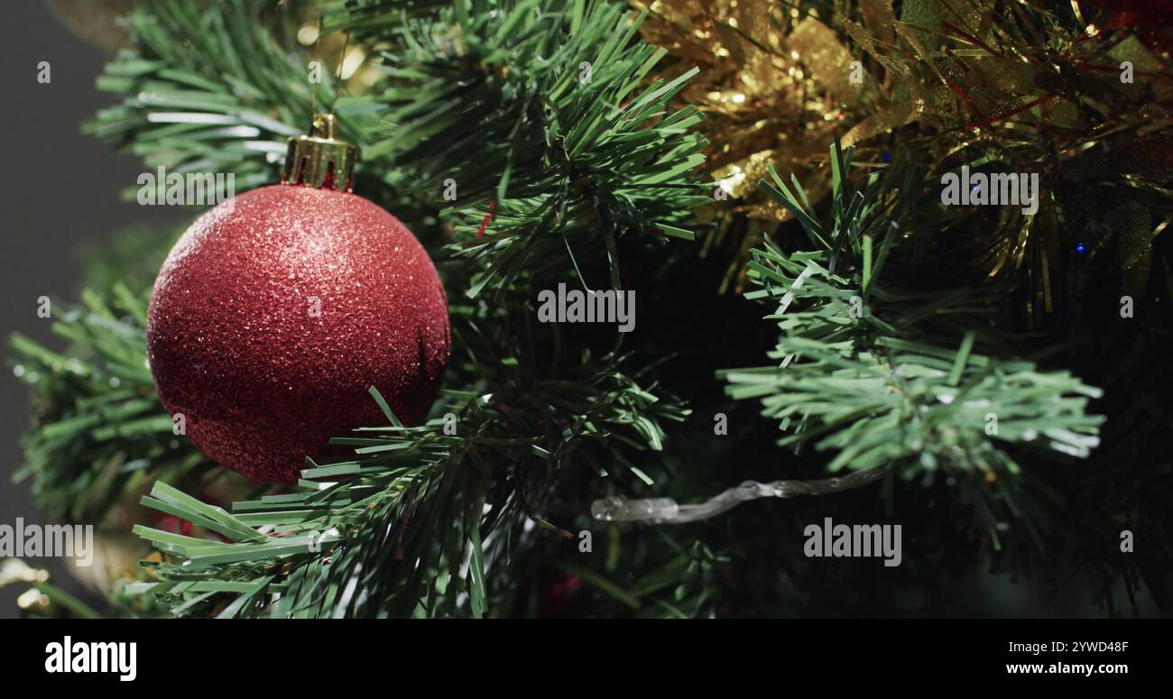 Ein rotes Weihnachtsschmuck hängt an einem Weihnachtsbaum Stockfoto