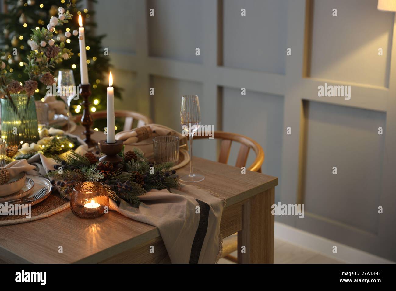 Weihnachtsfeier. Festlicher Tisch mit Geschirr, Gläsern und Dekor im Zimmer Stockfoto