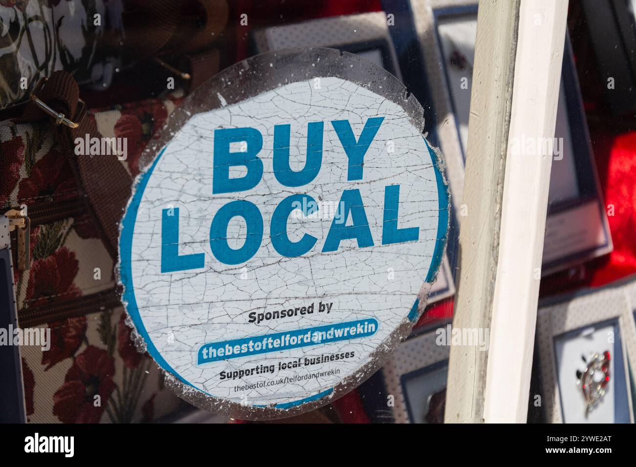 Ironbridge, Shropshire, Großbritannien, 22-06-2018. Ein Aufkleber „Buy local“ im Fenster eines Souvenirshops vor Ort. Stockfoto