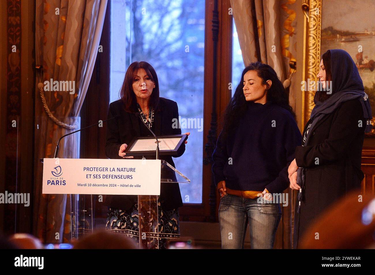 Paris, Frankreich. Dezember 2024. Die Pariser Bürgermeisterin Anne Hidalgo verleiht Paul Watson symbolisch die Ehrenbürgerschaft der Stadt Paris und überreicht sie dem Präsidenten Lamya Essemlali von Sea Shepherd France und der Frau von Paul Watson Yana Rusinovich auf einer Konferenz zum Thema „Schutz der Natur und ihrer Verteidiger“ im Pariser Rathaus, Frankreich, am 10. Dezember 2024. Foto: Karim Ait Adjedjou/ABACAPRESS. COM Credit: Abaca Press/Alamy Live News Stockfoto