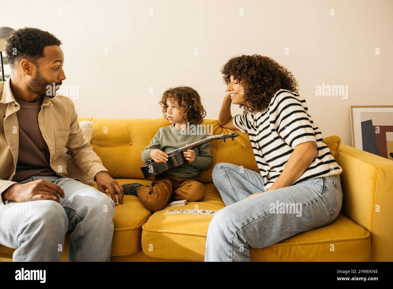 Eine Familie genießt eine gute Zeit zusammen, wenn sie auf einem Sofa sitzt, um sich unterhalten und Musik hören zu können. Stockfoto