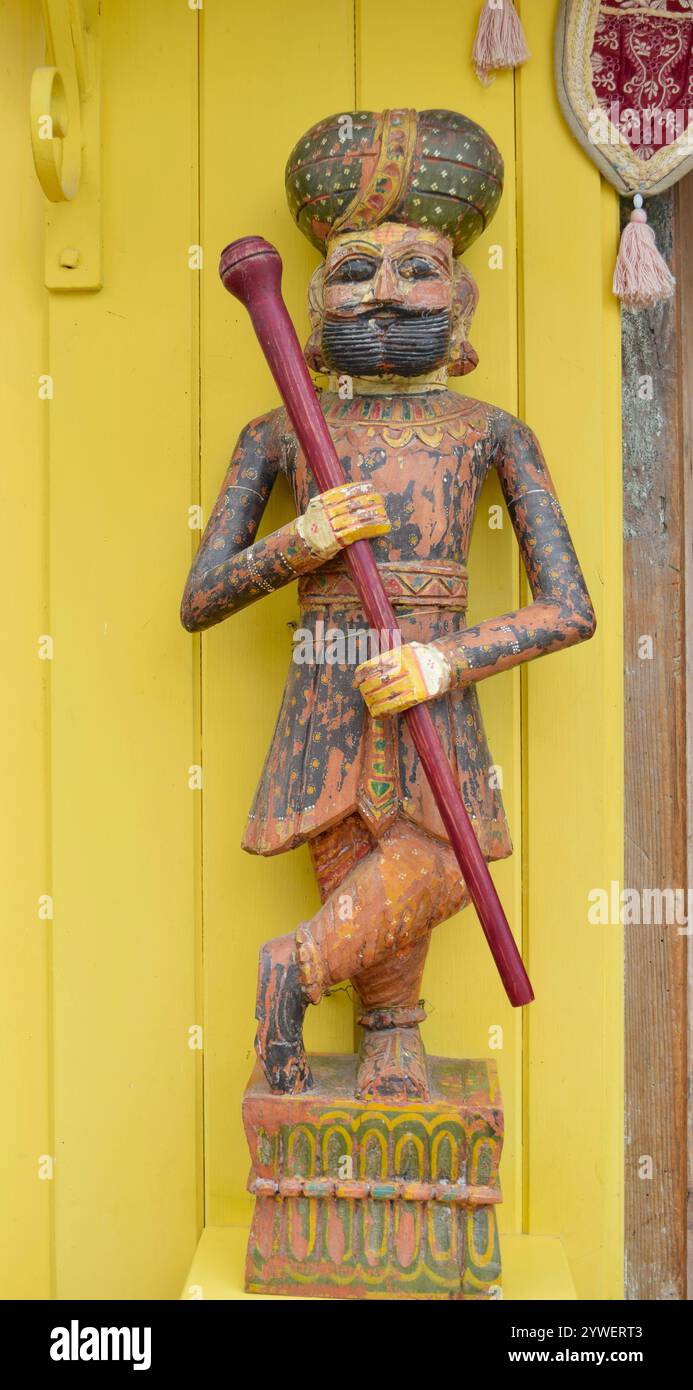 Indische hölzerne Statue auf hellgelbem Hintergrund. Stockfoto