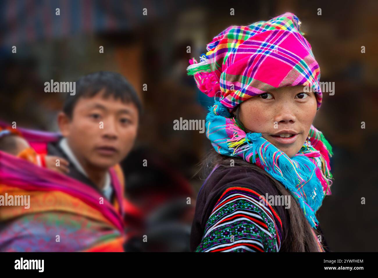 Hmong-Frau und Mann mit dem Baby auf dem Rücken des Mannes in Sapa, Vietnam Stockfoto