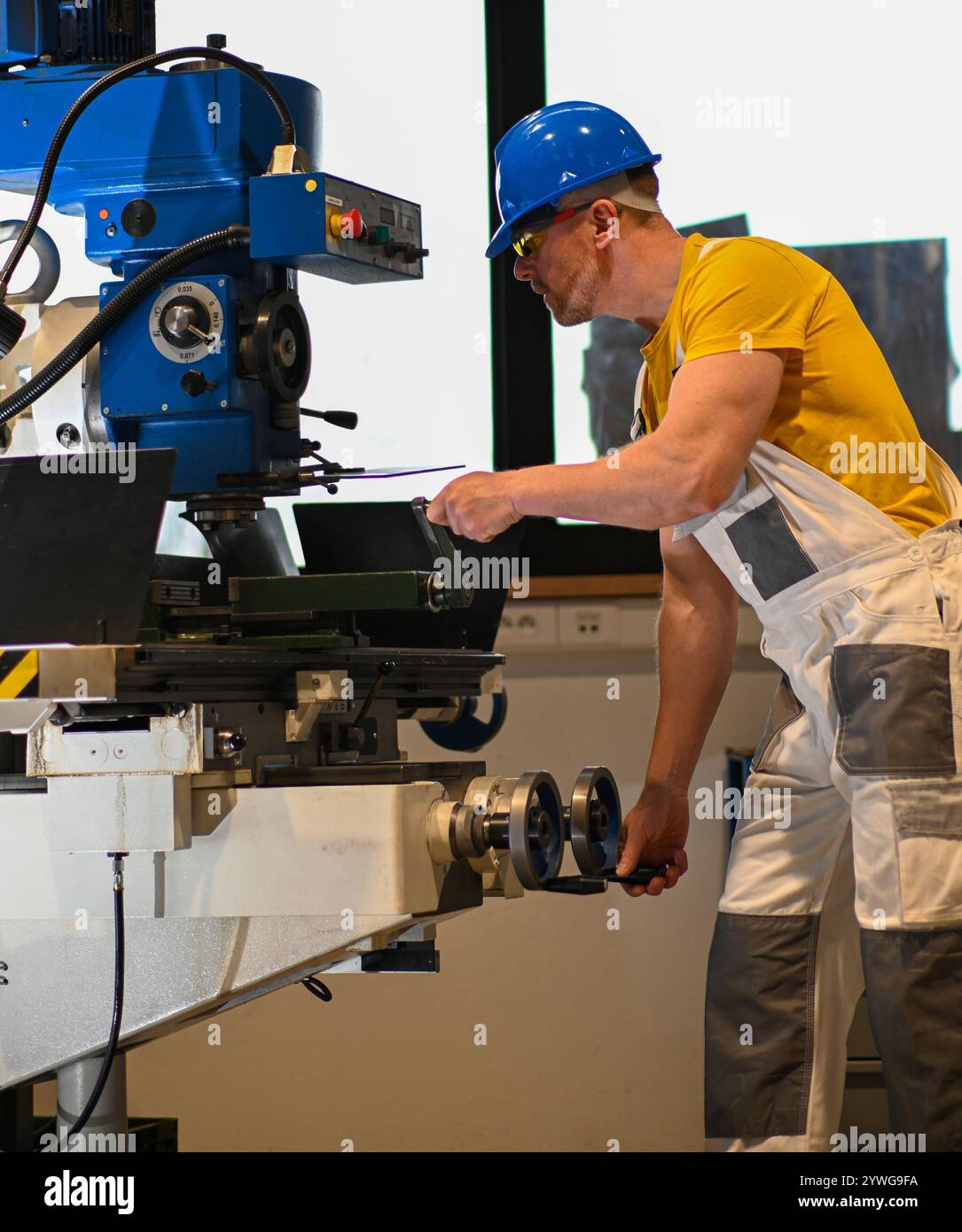 Fabrikarbeiter, der eine Fräsmaschine bedient, demonstriert die Sicherheit am Arbeitsplatz mit angemessener Kleidung und konzentrierter Aufmerksamkeit. Stockfoto Fabrikarbeiter, der eine Fräsmaschine bedient, demonstriert die Sicherheit am Arbeitsplatz mit angemessener Kleidung und konzentrierter Aufmerksamkeit. Stockfoto