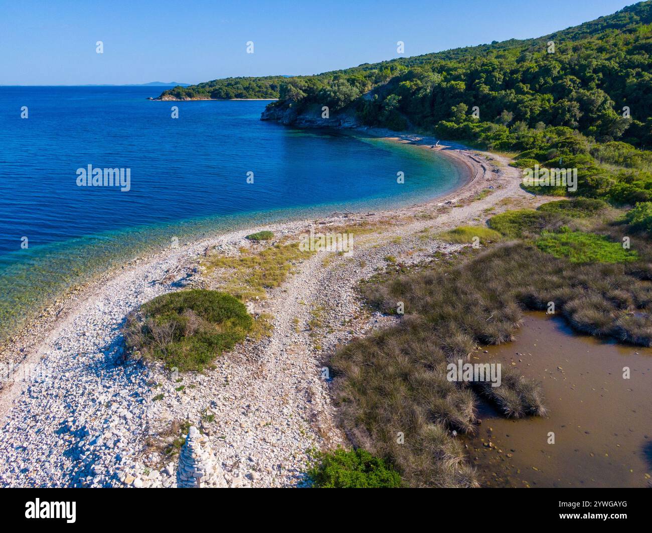 Abgeschiedene Bucht mit türkisfarbenem Wasser und üppigem Grün. Stockfoto