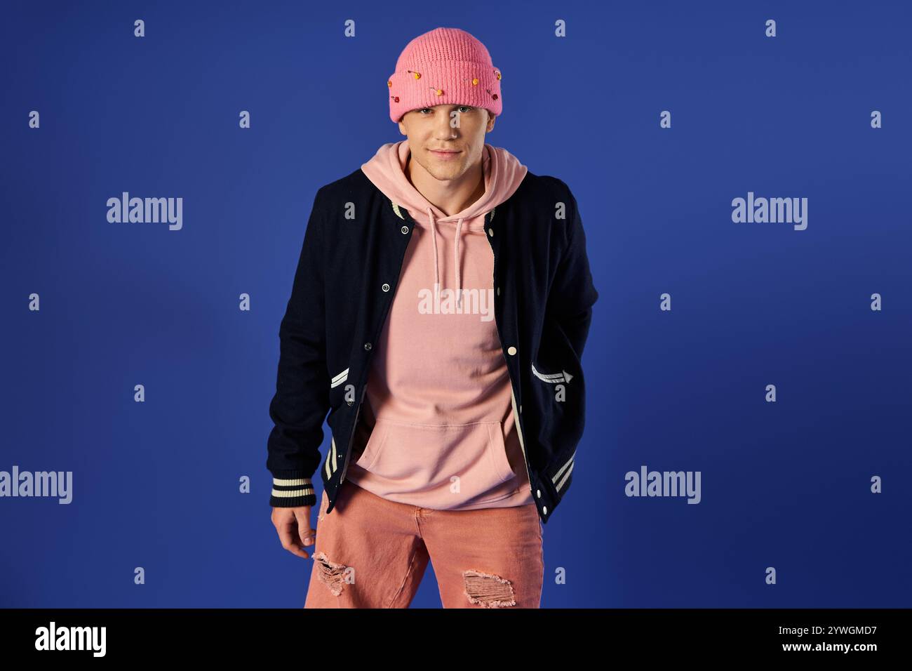 Junger Mann zeigt Selbstvertrauen und Stil in einer lebendigen Umgebung. Stockfoto