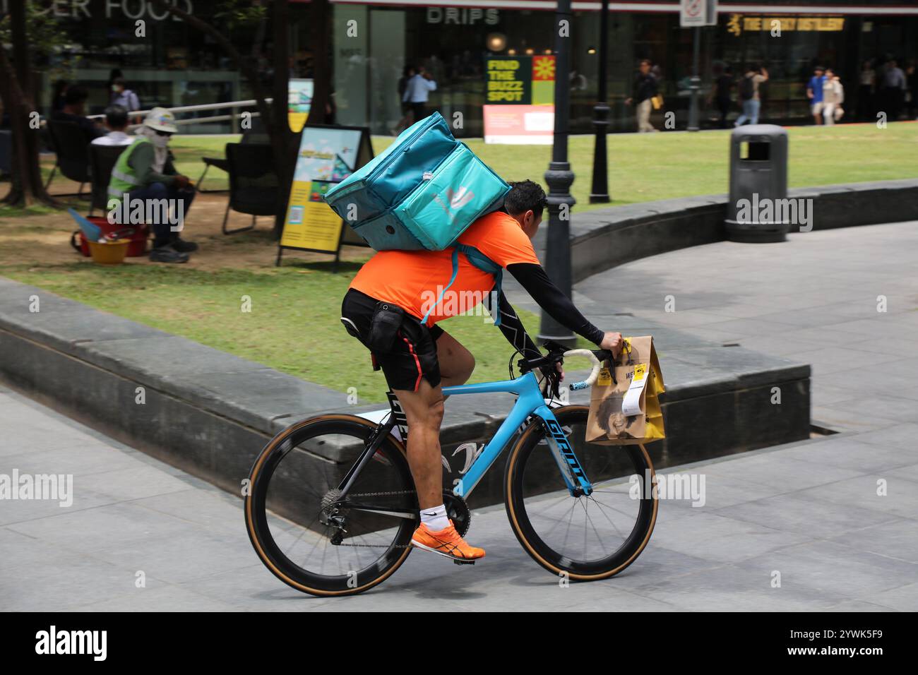 SINGAPUR CITY, SINGAPUR - 13. MÄRZ 2024: Radfahrer fahren mit Deliveroo Food Delivery Bag in Singapur. Deliveroo ist ein britisches Online-Food Delivery c Stockfoto