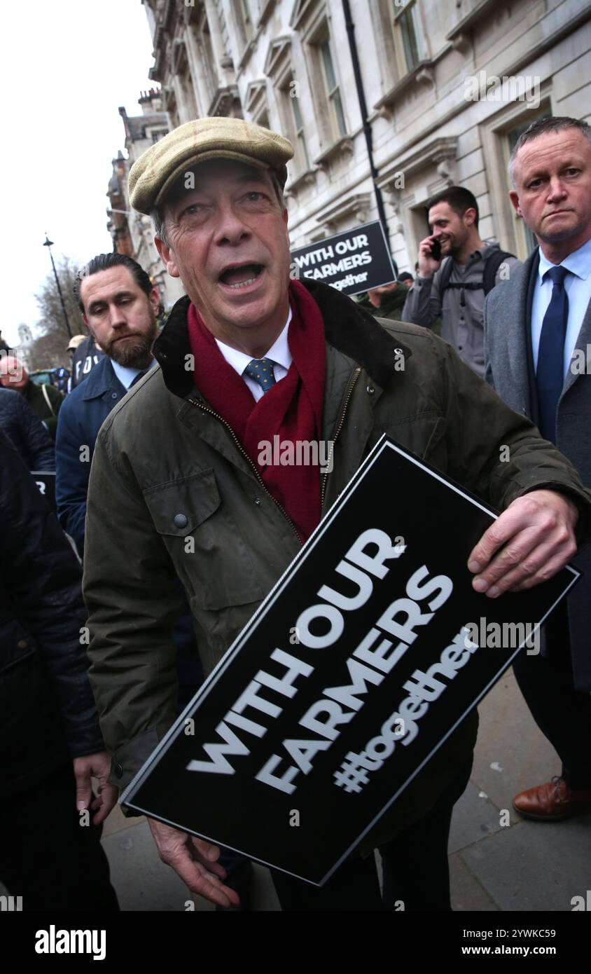 London, England, Großbritannien. Dezember 2024. Der Abgeordnete der Reform NIGEL FARAGE unterstützt die Bauern mit einem Zeichen während der Kundgebung. Die Bauern und ihre Unterstützer versammeln sich zum zweiten Mal innerhalb eines Monats im Londoner Whitehall gegenüber der Downing Street, um gegen die neuen Erbschaftssteuervorschriften zu protestieren, die die Labour-Kanzlerin RACHEL REEVES in ihrem Herbstbudget eingeführt hat. Die Landwirte werden 2026 20 % Erbschaftssteuer auf Vermögenswerte von über 1 Million Â zahlen, anstatt sie steuerfrei an ihre Familienangehörigen weiterzugeben. Landwirte beklagen sich, dass sie nicht zahlreich sind, und solche Steuerrechnungen werden dazu führen, dass Familienbetriebe p verkaufen müssen Stockfoto