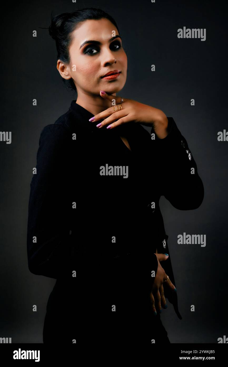 Ein atemberaubendes Solo-Bild eines großen weiblichen Models in einem klassischen schwarzen Anzug. Die schlanken Linien und der polierte Look betonen Eleganz, Schönheit und Vielseitigkeit Stockfoto
