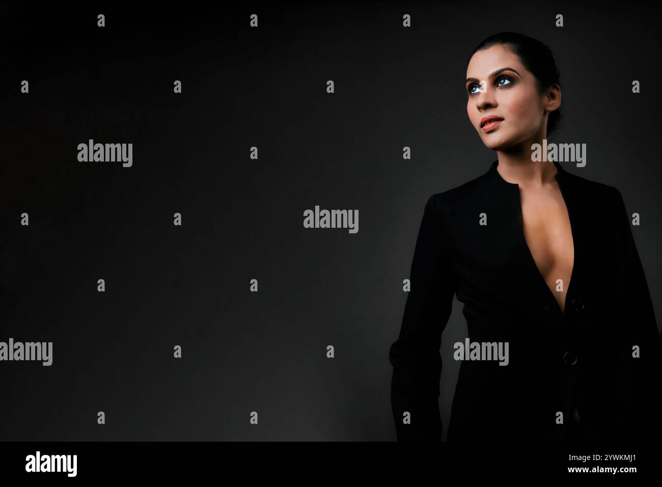 Ein atemberaubendes Solo-Bild eines großen weiblichen Models in einem klassischen schwarzen Anzug. Die schlanken Linien und der polierte Look betonen Eleganz, Schönheit und Vielseitigkeit Stockfoto