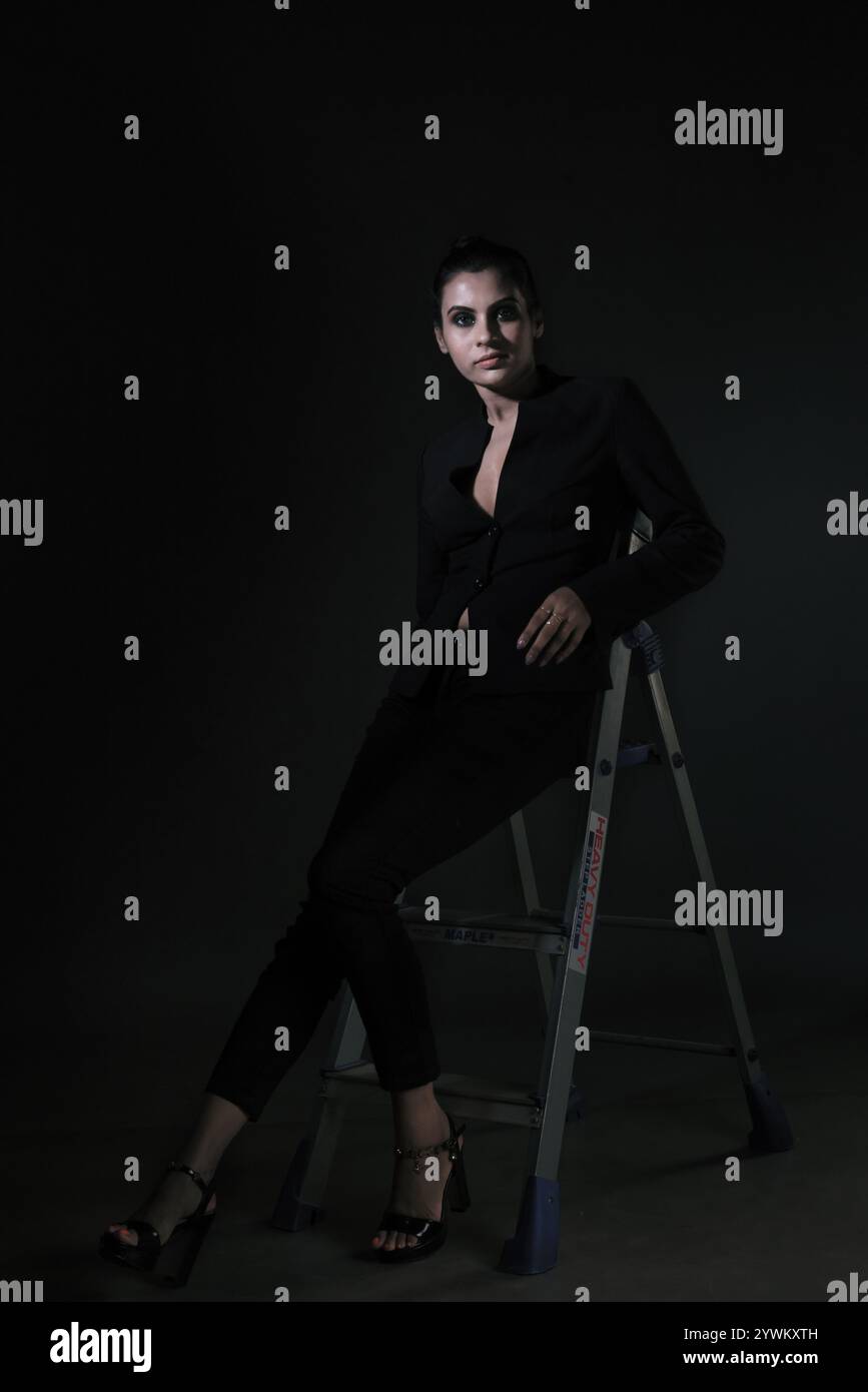 Ein atemberaubendes Solo-Bild eines großen weiblichen Models in einem klassischen schwarzen Anzug. Die schlanken Linien und der polierte Look betonen Eleganz, Schönheit und Vielseitigkeit Stockfoto