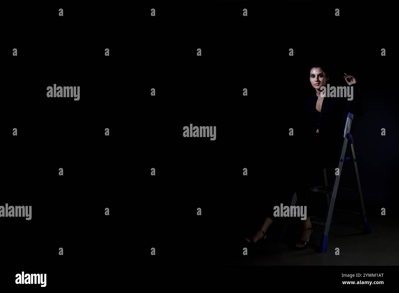 Ein atemberaubendes Solo-Bild eines großen weiblichen Models in einem klassischen schwarzen Anzug. Die schlanken Linien und der polierte Look betonen Eleganz, Schönheit und Vielseitigkeit Stockfoto