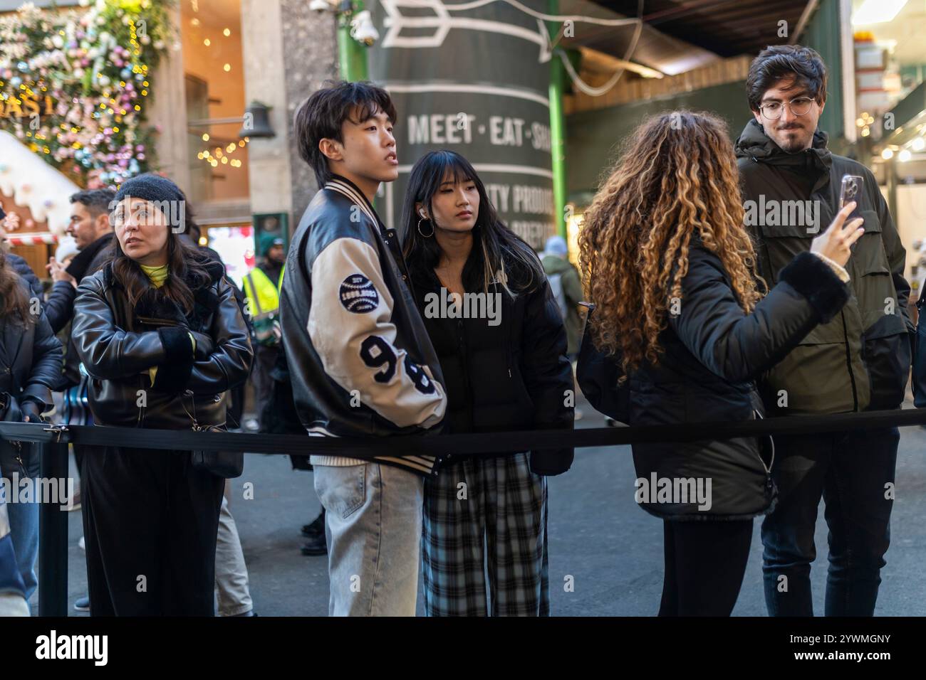 London, Großbritannien - 24. November 2024, Eine Reihe von Leuten, die auf Paella am Borough Market warten. Junge Menschen stehen in Schlange. Stockfoto