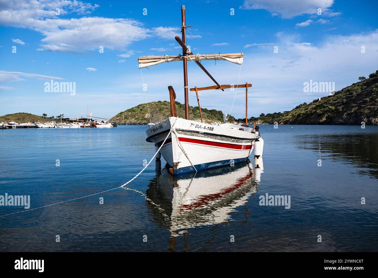 Ein traditionelles Segelboot aus Holz, das in der Bucht von Portlligat in der Morgensonne in Cadaqués, Katalonien, Spanien vor Anker liegt Stockfoto