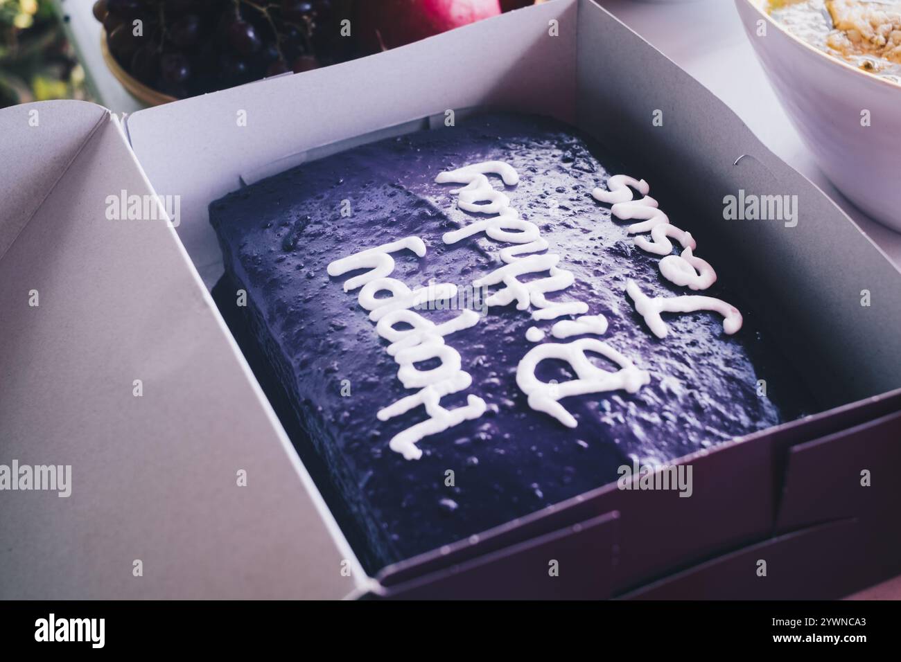 Lilafarbener Yamskuchen mit Schriftzug „Happy Birthday Jesus“ auf der Party zum frohen Weihnachtsfeiertag. Selektiver Fokus. Isoliert. Nahaufnahme. Stockfoto
