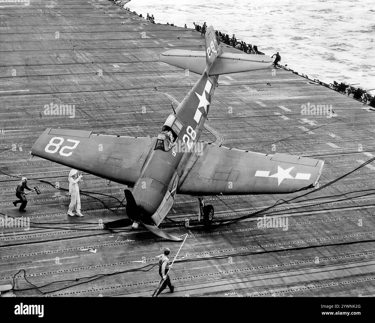 Ein umkämpfter Grumman F6F Hellcat auf dem Flugdeck der USS Hornet während der Schlacht an der Philippinischen See im Juni 1944. Das amerikanische Trägerflugzeug des Zweiten Weltkriegs feierte sein Kampfdebüt im September 1943 und etablierte sich anschließend als robuster, gut konstruierter Trägerflugzeug. In der zweiten Hälfte des Pazifikkrieges wurde sie zum dominierenden Jagdflugzeug der United States Navy. Insgesamt wurden 12.275 in etwas mehr als zwei Jahren gebaut und Hellcats wurde zugeschrieben, während sie im Dienst waren, insgesamt 5.223 feindliche Flugzeuge zu zerstören. Stockfoto