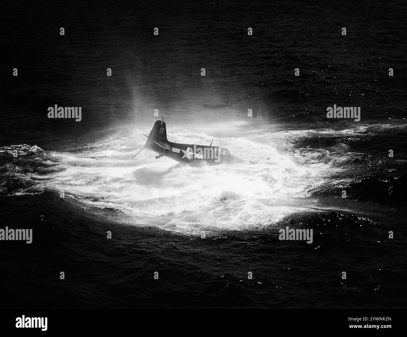 Ein umkämpfter Grumman F6F Hellcat im Meer vor der USS Hancock während der Schlacht auf der Philippinischen See im Juli 1944. Das amerikanische Trägerflugzeug des Zweiten Weltkriegs feierte sein Kampfdebüt im September 1943 und etablierte sich anschließend als robuster, gut konstruierter Trägerflugzeug. In der zweiten Hälfte des Pazifikkrieges wurde sie zum dominierenden Jagdflugzeug der United States Navy. Insgesamt wurden 12.275 in etwas mehr als zwei Jahren gebaut und Hellcats wurde zugeschrieben, während sie im Dienst waren, insgesamt 5.223 feindliche Flugzeuge zu zerstören. Stockfoto