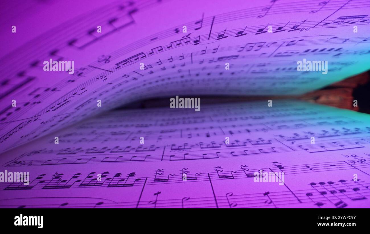Makrohintergrund eines geretteten mittelalterlichen Buches mit alten Notenschriften, Glowing Neon Light. Textur alter handgeschriebener klassischer Sinfonie Stockfoto