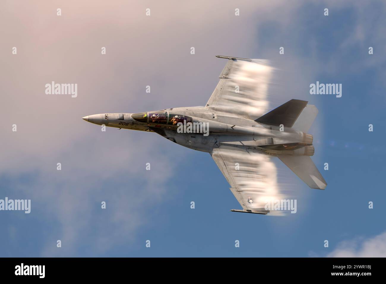 Eine F/A-18 Super Hornet der US Navy, die einen Hochgeschwindigkeitspass mit sichtbarer Kondensation durchführt. Stockfoto