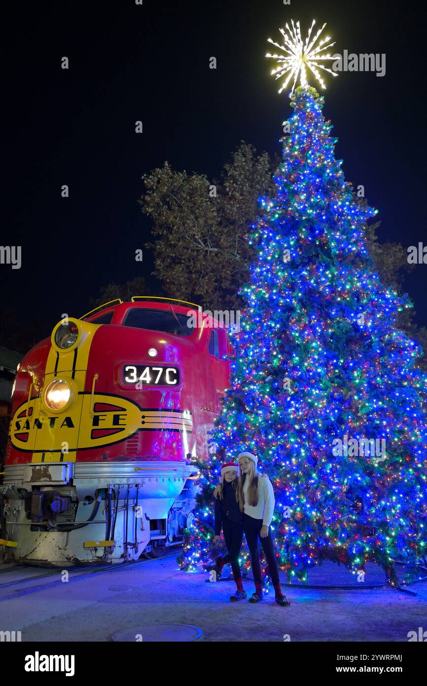 Eine rote Lokomotive und ein beleuchteter Weihnachtsbaum am historischen Bahnhof Old Sacramento CA Stockfoto
