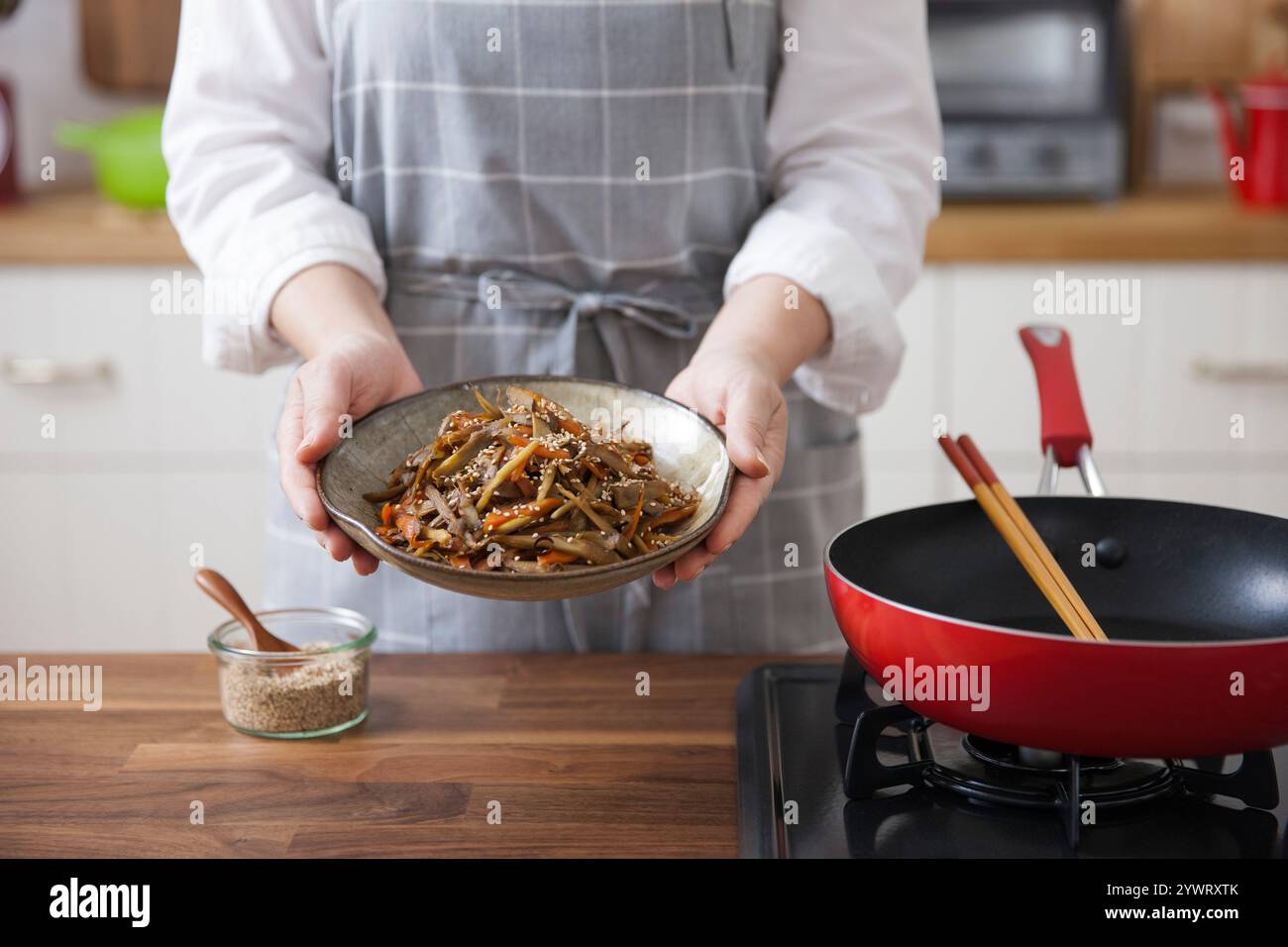 Eine Frau, die eine Schüssel Kinpira Gobo hält. Stockfoto