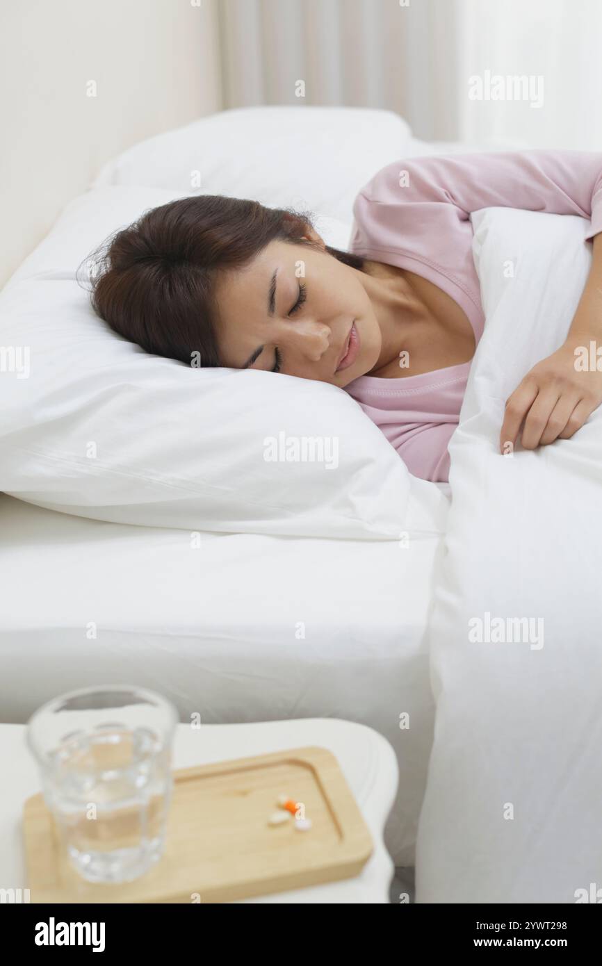 Frau liegend krank und Medizin auf dem Tisch Stockfoto