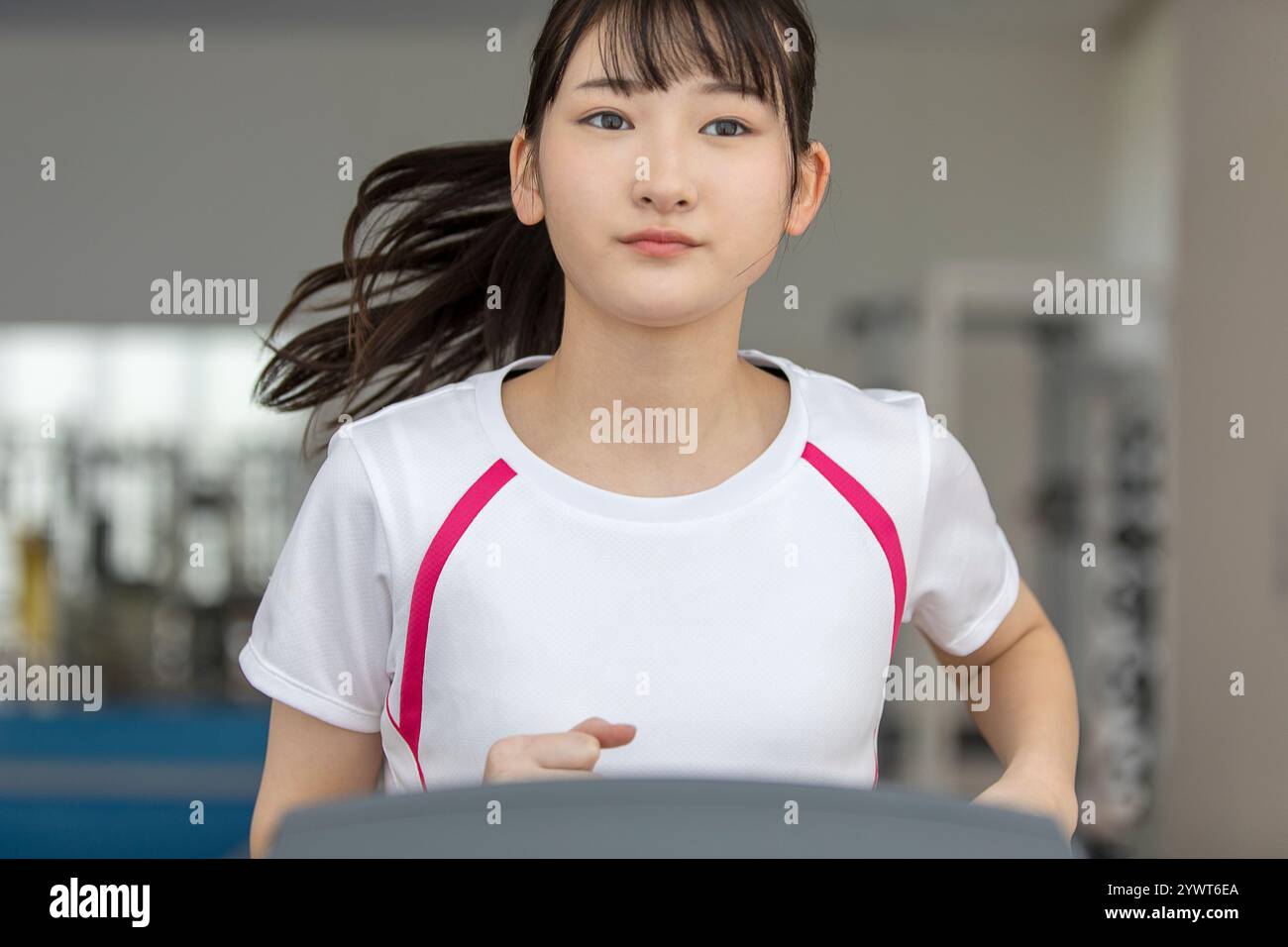 Eine japanische Frau, die auf einer Laufmaschine läuft Stockfoto