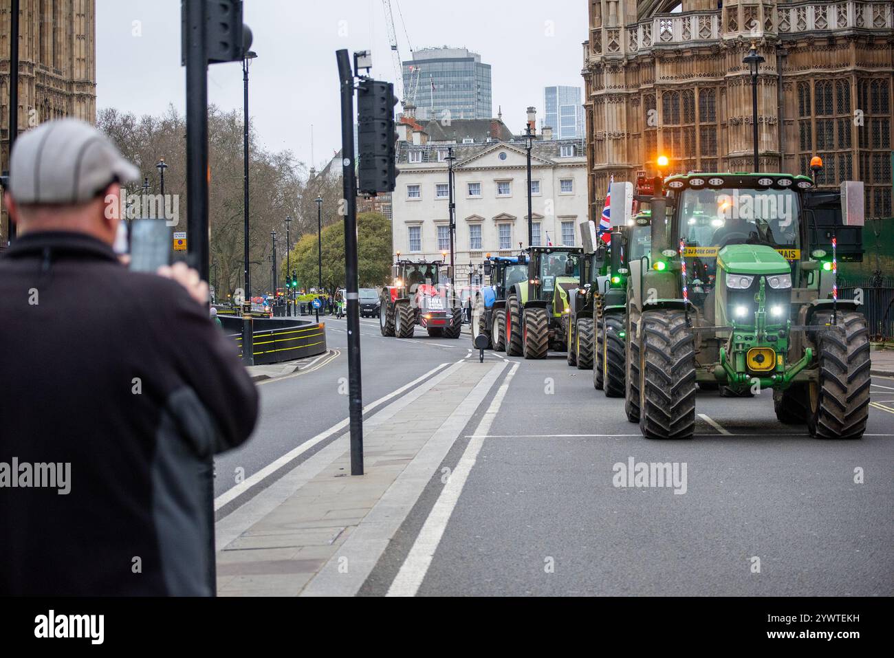 London, Großbritannien. Dezember 2024. Ein Mann fotografiert im Parlament von den ankommenden Traktoren in London. Mehr als 600 Traktoren trafen im Whitehall ein, um eine Demonstration durchzuführen, die von Save British Farming (SBF) und Kent Fairness für Landwirte organisiert wurde. Die Demonstranten demonstrierten gegen die Politik der Regierung, die der britischen Landwirtschaft feindlich gegenübersteht. (Foto: Krisztian Elek/SOPA Images/SIPA USA) Credit: SIPA USA/Alamy Live News Stockfoto