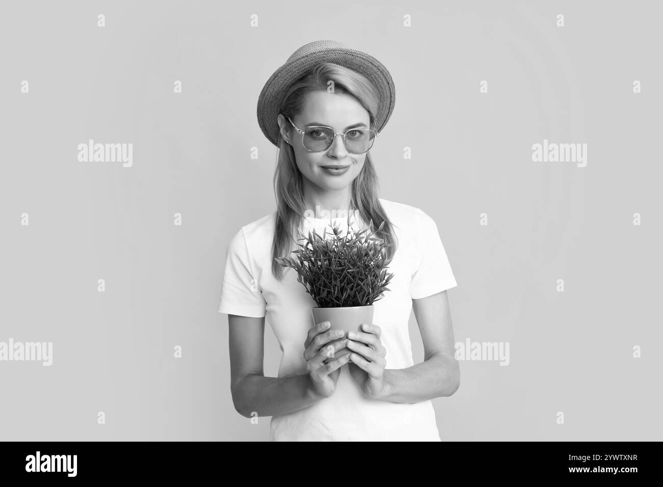 Sommer Gärtnerin Frau isoliert auf gelbem Hintergrund. Rotschopf lustiges Mädchen Pflanzen Blumen in Topf. Stockfoto